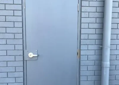 Metal latch and strike plate on a white door frame