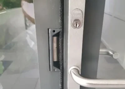 Round lock cylinder on the edge of a grey door