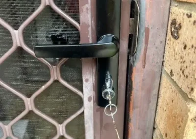 Black digital smart lock with blue indicator on a timber door