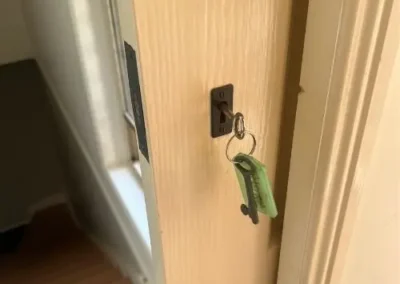 Brass lock cylinder with keyring in a cream door