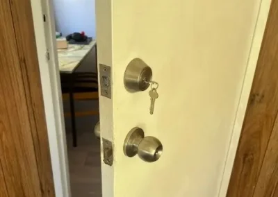 Silver door knob with a key in the round lock above