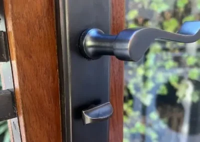 Black lever handle and round lock on a timber door