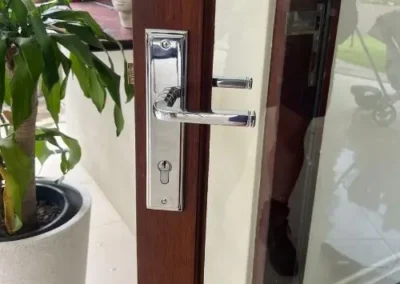 Silver lever handle on a long backplate fitted to a glass-panel door
