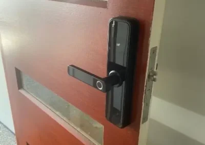 Black digital lever lock fitted to a timber door
