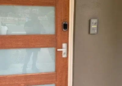 White lever handle and black lock on a frosted-glass timber door