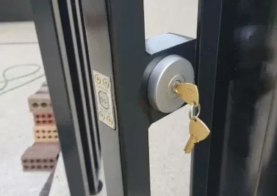Deadbolt lock with key inserted beside a glass door
