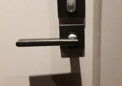 Black lever lock fitted to a white door