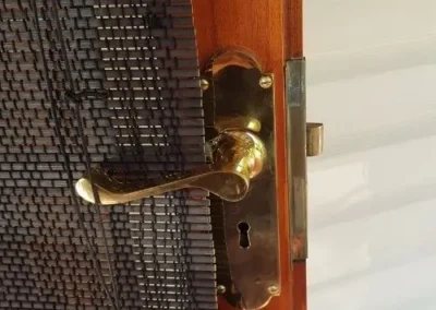 Brass door handle fitted to a security screen