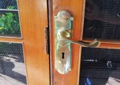 Brass handle and lock on a screened entry door