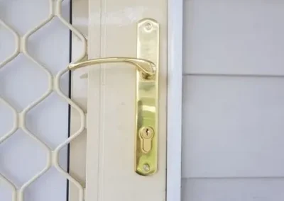 Gold handle fitted to a security screen door